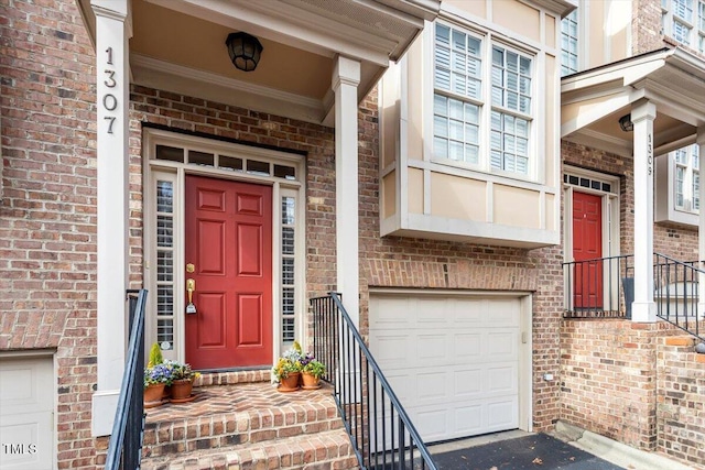 entrance to property featuring brick siding and an attached garage