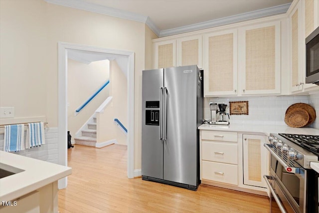 kitchen featuring stainless steel appliances, light countertops, light wood-type flooring, decorative backsplash, and crown molding