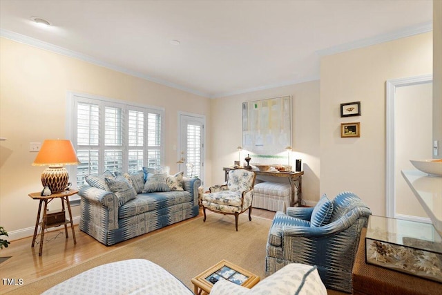 living area featuring ornamental molding, baseboards, and wood finished floors