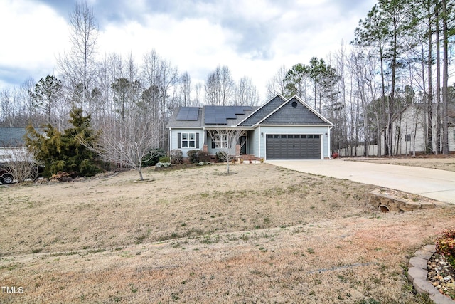 view of front of property with driveway, an attached garage, and solar panels