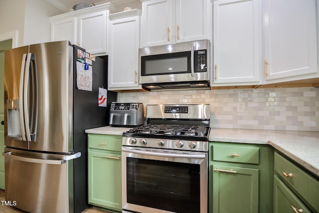 kitchen with white cabinets, green cabinetry, stainless steel appliances, light countertops, and backsplash