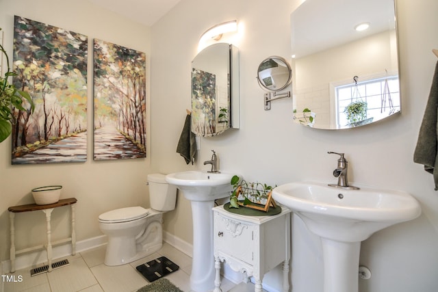 bathroom with toilet, tile patterned flooring, visible vents, and baseboards