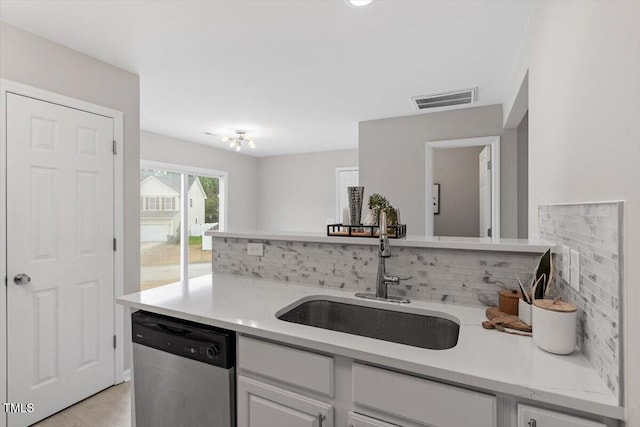 kitchen with visible vents, a sink, light countertops, stainless steel dishwasher, and tasteful backsplash