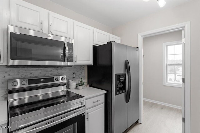 kitchen featuring decorative backsplash, light countertops, white cabinets, and appliances with stainless steel finishes