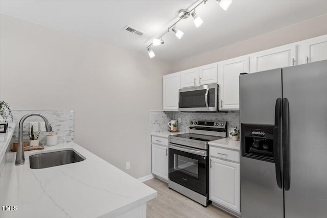 kitchen featuring tasteful backsplash, visible vents, appliances with stainless steel finishes, and a sink