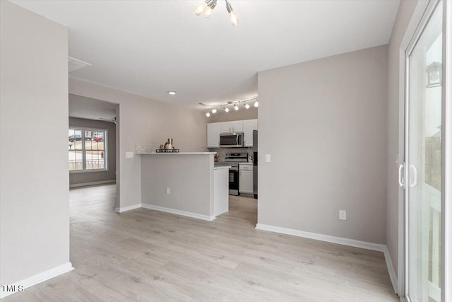 unfurnished living room featuring baseboards and light wood-type flooring