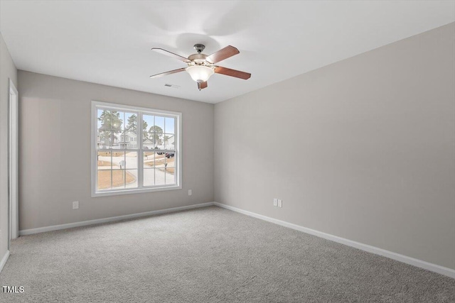 spare room with visible vents, carpet floors, baseboards, and ceiling fan