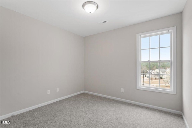 carpeted spare room with visible vents and baseboards