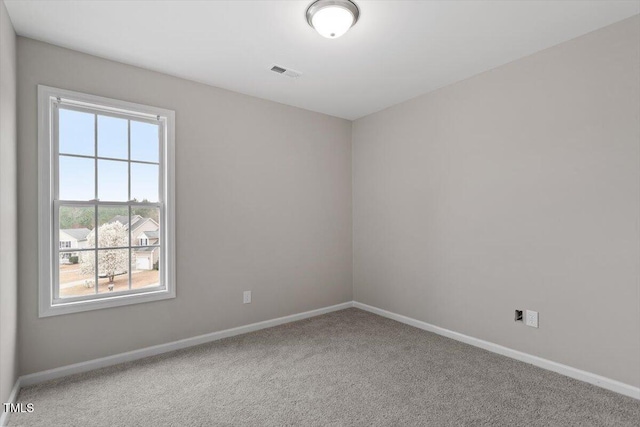 spare room featuring visible vents, baseboards, and carpet floors