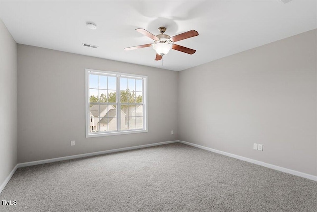 empty room featuring baseboards, visible vents, carpet floors, and ceiling fan