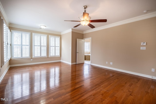 empty room with ornamental molding, a ceiling fan, hardwood / wood-style floors, and baseboards