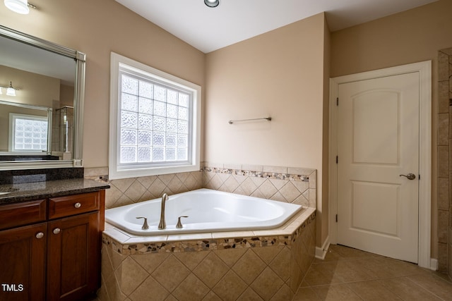 bathroom featuring a bath, a shower with shower door, vanity, and tile patterned floors