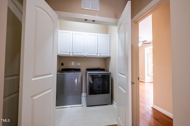 clothes washing area with cabinet space, visible vents, ceiling fan, separate washer and dryer, and baseboards