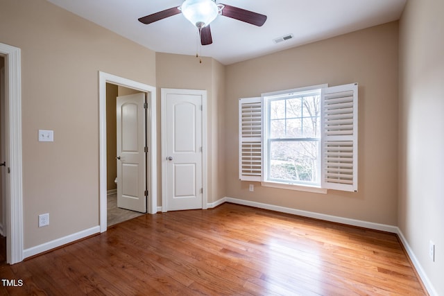 unfurnished bedroom featuring light wood finished floors, baseboards, visible vents, and a ceiling fan