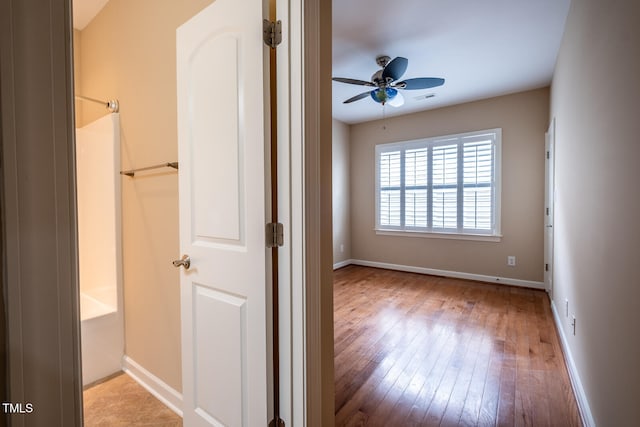 unfurnished bedroom featuring visible vents, hardwood / wood-style floors, and baseboards