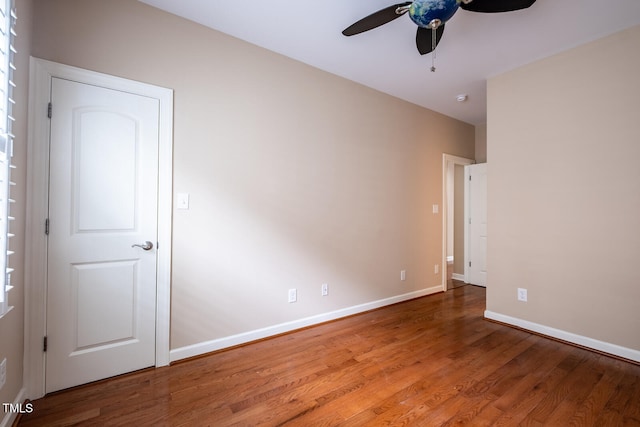 unfurnished room featuring a ceiling fan, baseboards, and wood finished floors