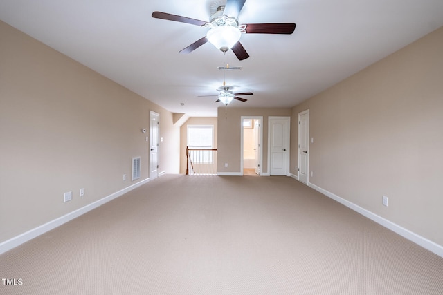 empty room with baseboards, visible vents, and carpet flooring