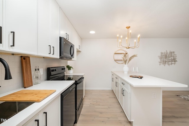 kitchen featuring a peninsula, black appliances, light wood-style flooring, and light countertops