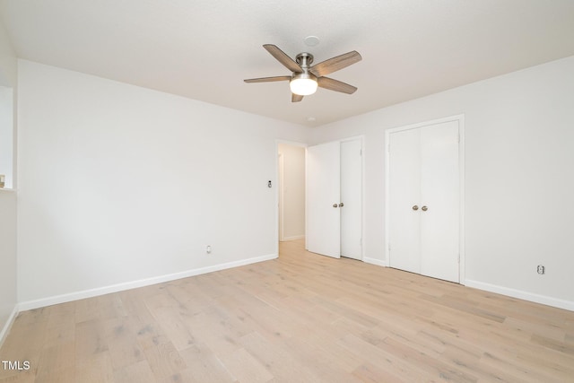 unfurnished bedroom featuring light wood-type flooring, baseboards, and a ceiling fan