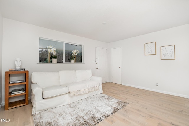 living area featuring baseboards and wood finished floors