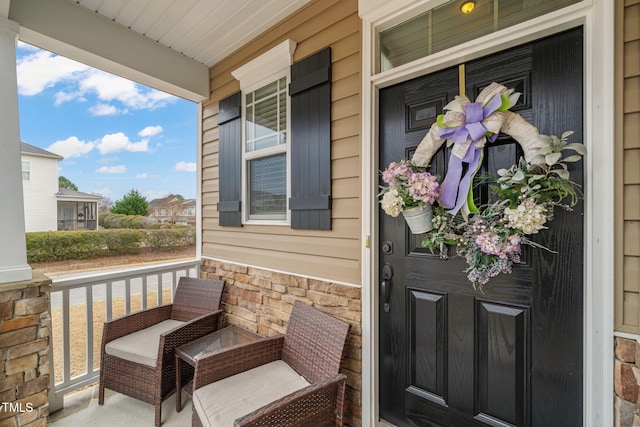 entrance to property featuring stone siding and a porch