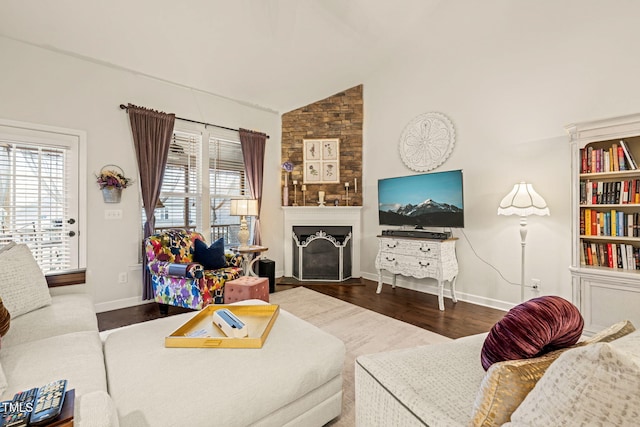 living area with a fireplace, wood finished floors, baseboards, and high vaulted ceiling