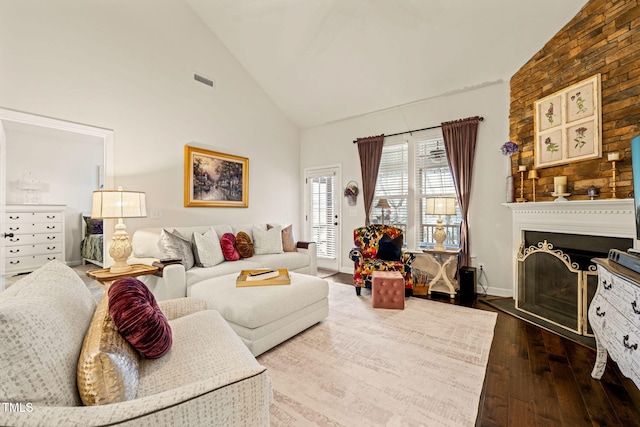 living area with high vaulted ceiling, hardwood / wood-style flooring, a fireplace, and baseboards