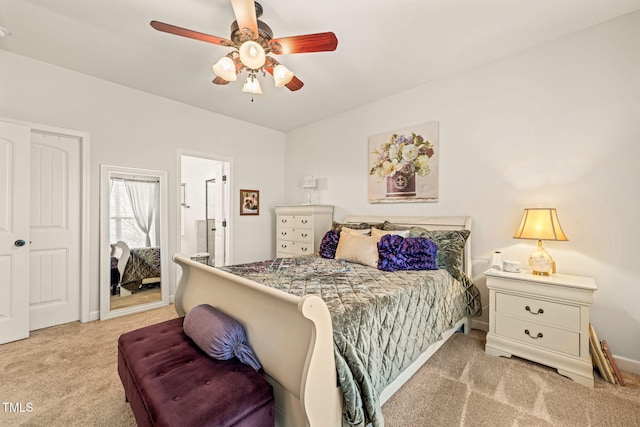 carpeted bedroom featuring ensuite bathroom and a ceiling fan
