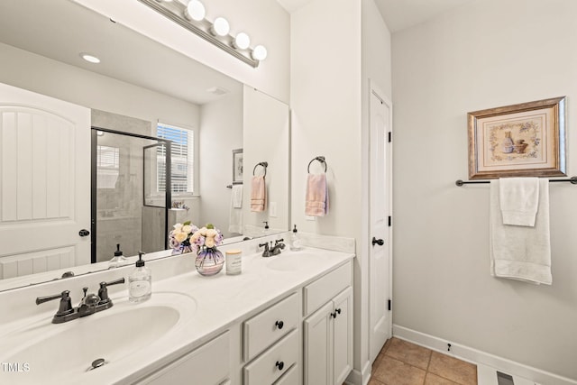 full bathroom featuring a shower stall, tile patterned floors, double vanity, and baseboards