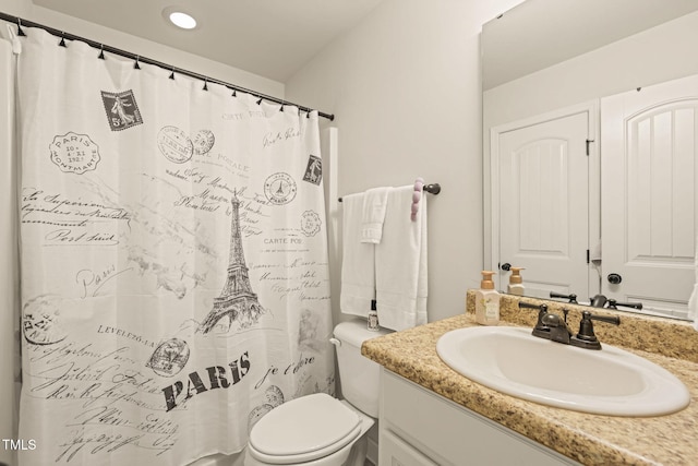 bathroom featuring toilet, vanity, and curtained shower