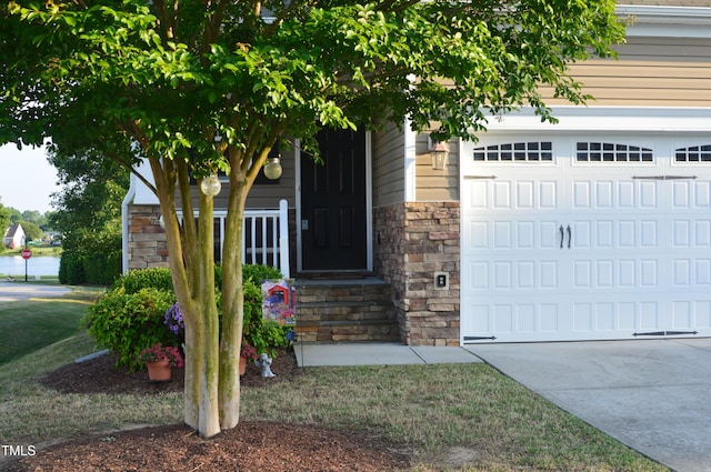entrance to property with stone siding and concrete driveway