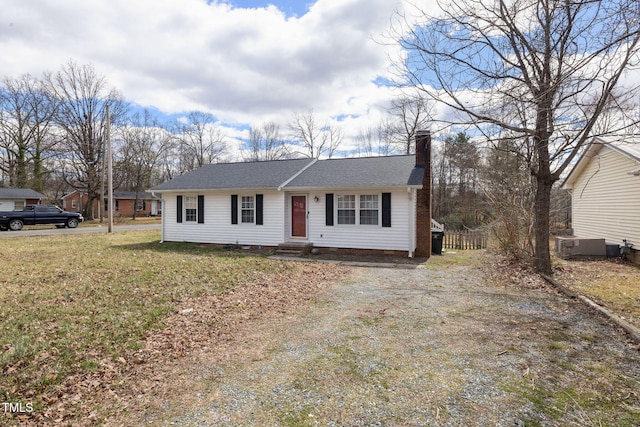 view of front of house with a front yard, a chimney, dirt driveway, and entry steps