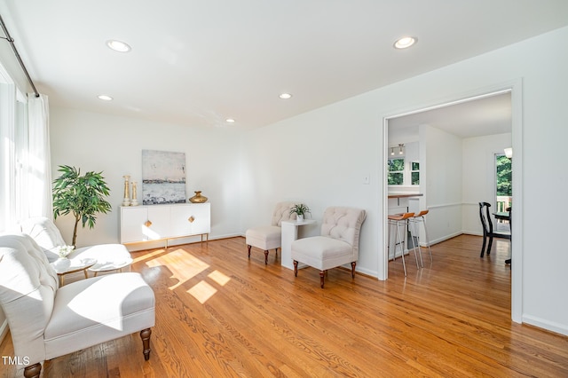 living area featuring baseboards, recessed lighting, and light wood-style floors