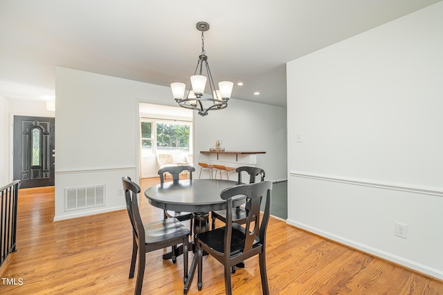 dining space with visible vents, baseboards, light wood-style flooring, an inviting chandelier, and recessed lighting