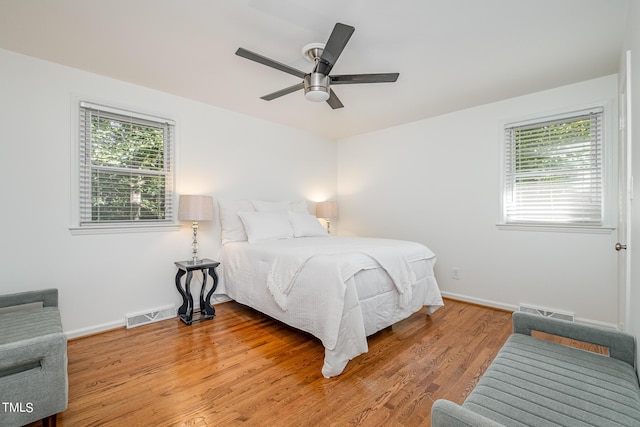 bedroom with light wood-style flooring, multiple windows, and visible vents