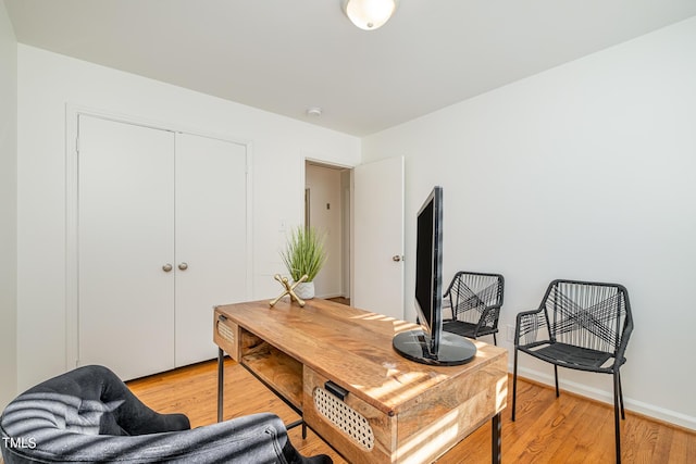 home office with baseboards and light wood finished floors