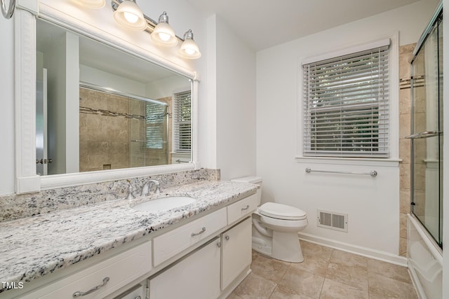 bathroom with toilet, vanity, visible vents, and baseboards