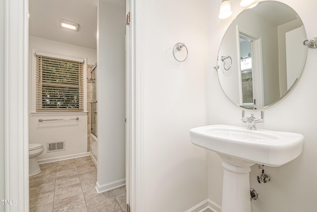 full bath with toilet, shower / bath combination with glass door, baseboards, and visible vents