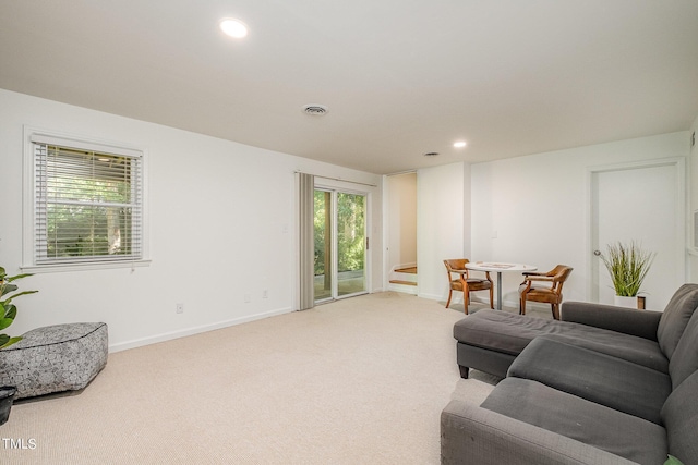 living room featuring baseboards, recessed lighting, and light colored carpet