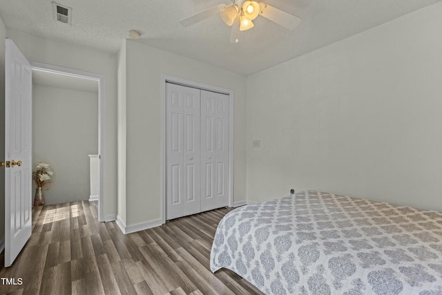 bedroom featuring a closet, visible vents, a ceiling fan, wood finished floors, and baseboards