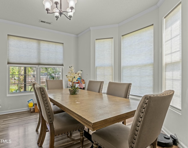 dining area with ornamental molding, visible vents, a notable chandelier, and baseboards