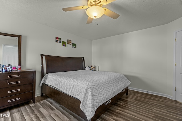 bedroom with a ceiling fan, baseboards, and wood finished floors