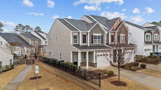 view of property with driveway, a garage, stone siding, a residential view, and fence