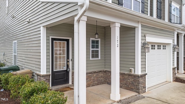 view of exterior entry with a garage and stone siding