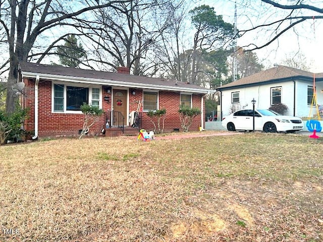 ranch-style home with a front yard, crawl space, brick siding, and a chimney