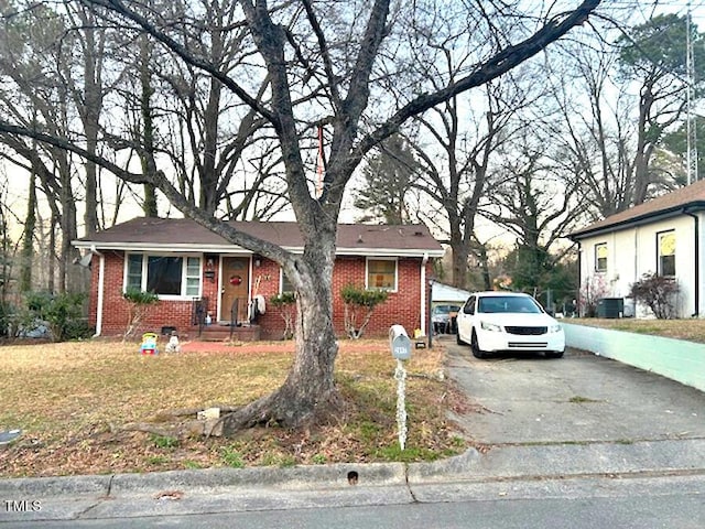 view of front facade with a front lawn, aphalt driveway, and brick siding