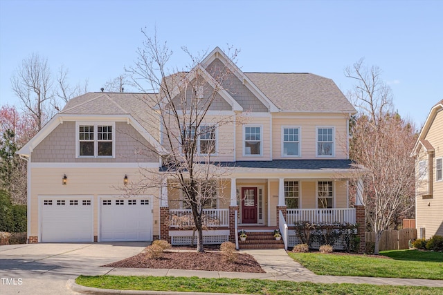 craftsman inspired home with a porch, concrete driveway, a garage, and fence