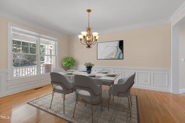 dining room featuring a notable chandelier, wood finished floors, and ornamental molding