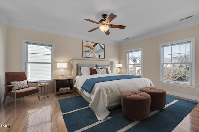 bedroom with visible vents, ornamental molding, baseboards, and hardwood / wood-style flooring