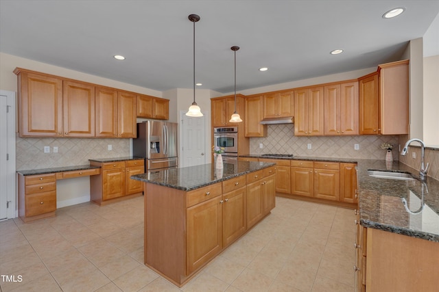 kitchen with a sink, stainless steel appliances, a kitchen island, and dark stone counters